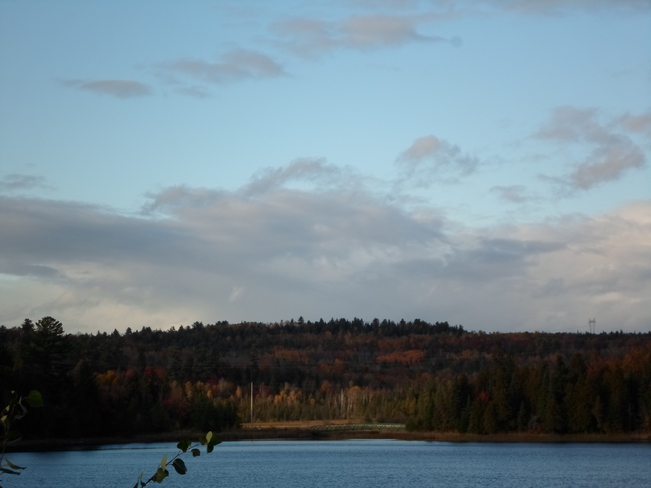 Sunshine on the trees across the water Elliot Lake, Ontario Canada