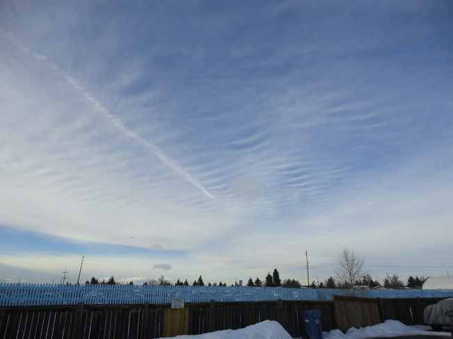 Wavy hazy cloud with jet contrail emission . Calgary, Alberta Canada