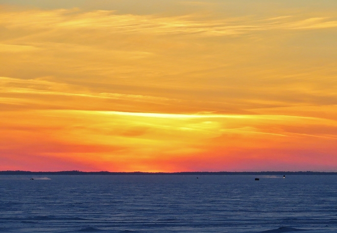 Cold weather sunset as ice fishermen head home. North Bay, Ontario Canada