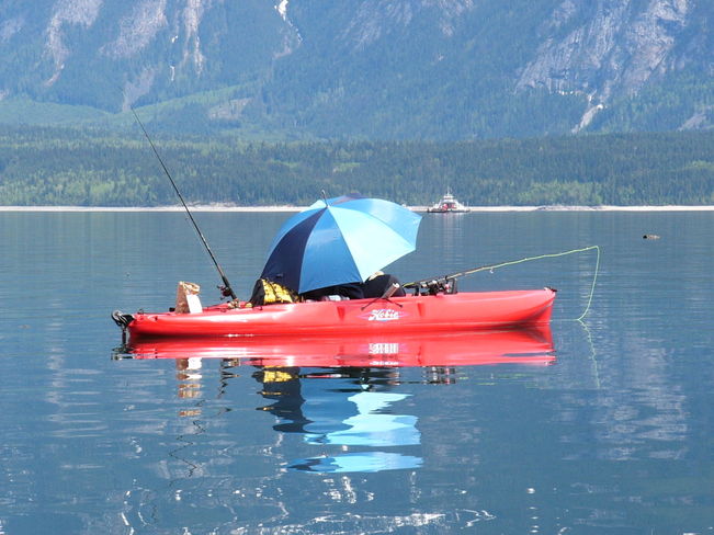 Arrow Lakes spring Kokanee fishing from a kayak. BC Ferry in background Arrow Lakes, BC