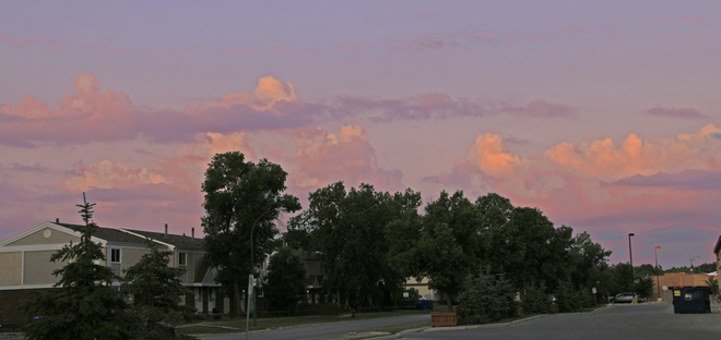 Cumulus clouds in the southwest catch the colors of the sunrise: Winnipeg, MB