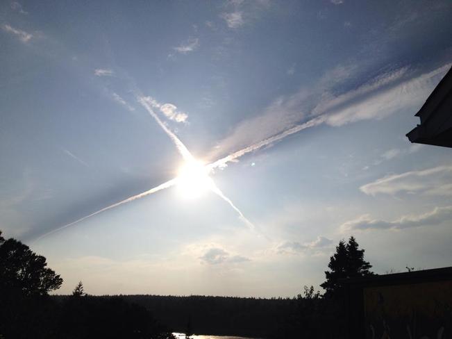 The sun in the centre of 2 jet contrails. Saint John, NB