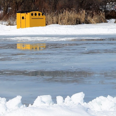 Yellow shed by frozen lake on a beautiful winter day Port Perry, Ontario