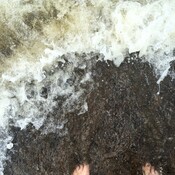Les pieds dans une vague