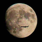 Jet plane flying in front of the moon