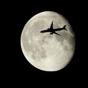 Plane flying across the moon