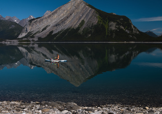 paddling along the shore of a still lake